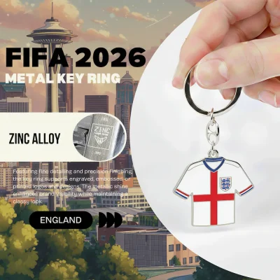 England national football team FIFA 2026 metal key ring, zinc alloy jersey-shaped key chain with England Football Association three lions crest, white soccer jersey with St. George's Cross design, fine detailing and precision finishing, metallic shine, classy look, FIFA 2026 World Cup fan accessory