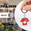 Canada national football team FIFA 2026 metal key ring, zinc alloy jersey-shaped key chain with Canadian maple leaf and Canada Soccer crest, red soccer jersey design, fine detailing and precision finishing, metallic shine, classy look, FIFA 2026 World Cup fan accessory